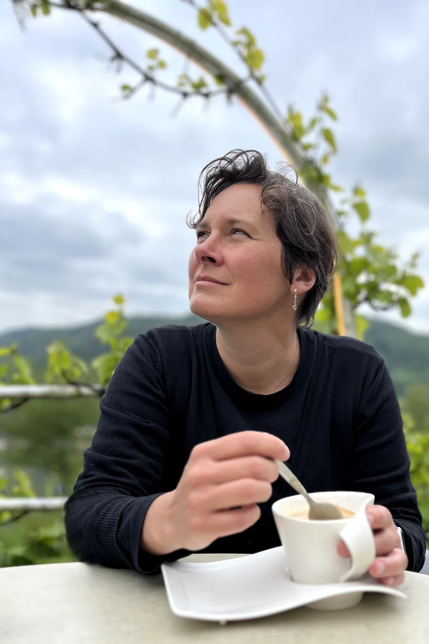 Agathe Schnorrenberg trinkt draussen einen Kaffee und schaut nach links oben